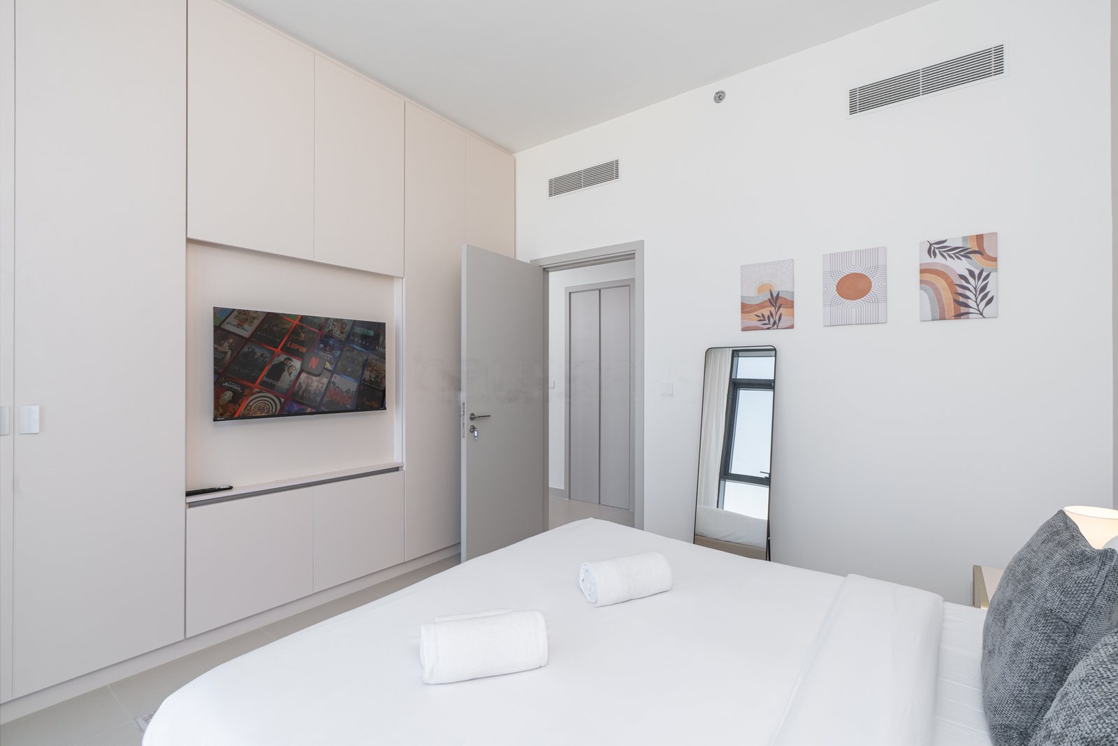Bedroom with fitted wardrobes, smart TV and full-length mirror